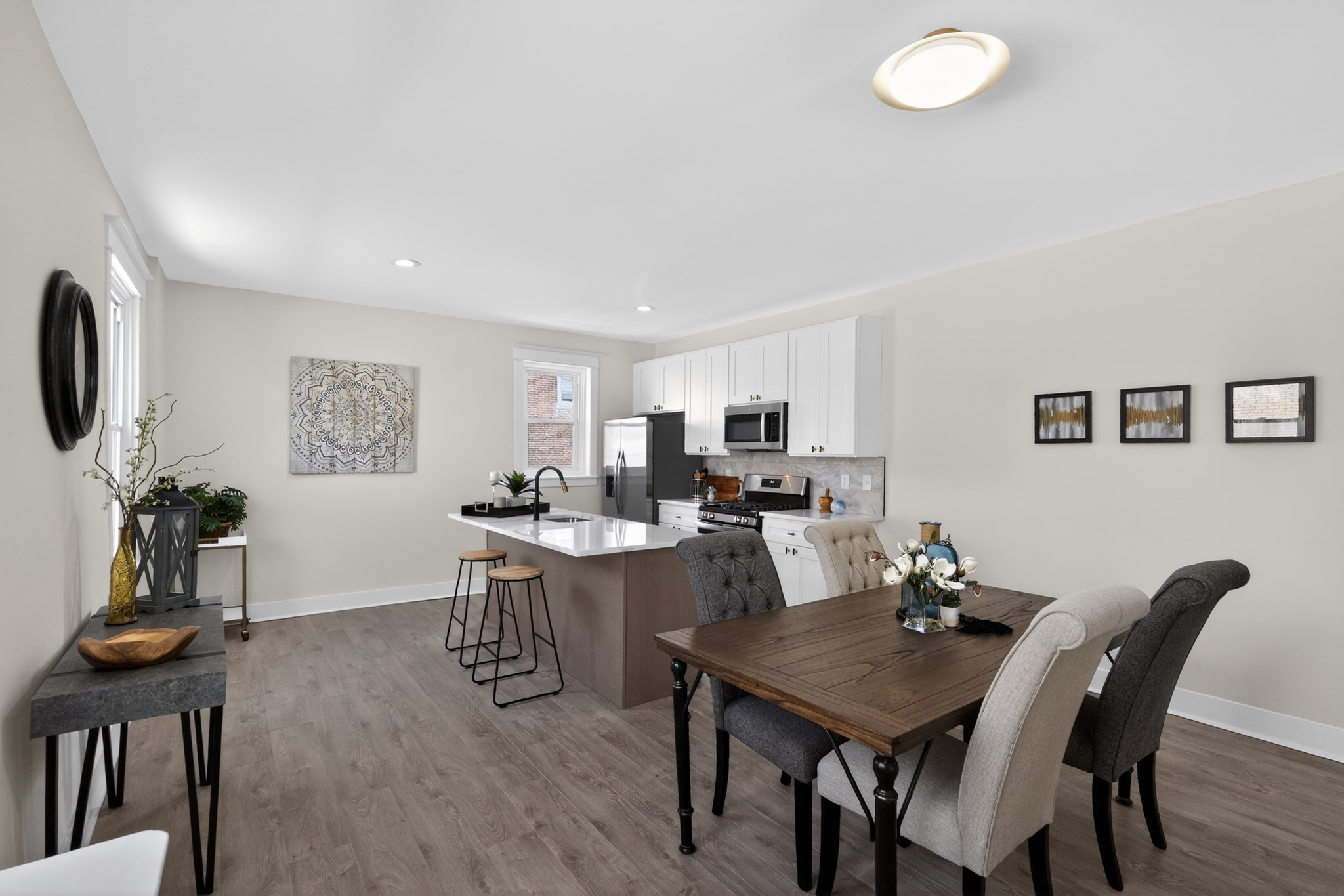 Open kitchen and dining room renovation with white cabinets, quartz island, and hardwood floors